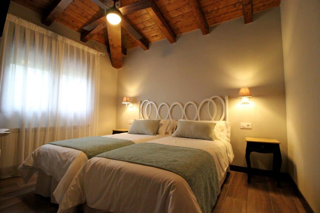 Habitación doble del Alojamiento Rural en la Vera con techos de madera y cama con dosel en el Hotel Rural San Giles.